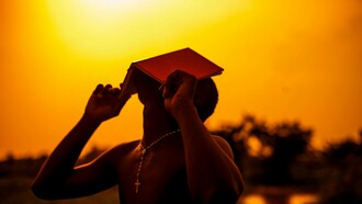 Homem segura um livro aberto diante do rosto, em meio à luz do entardecer. Entre palavras, pensamentos e interpretações, a linguagem também participa da maneira como percebemos e construímos o mundo