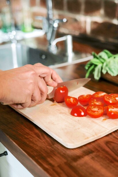Chef corta tomates cereja para o molho