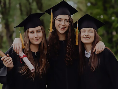 Three students elegantly don their graduation gowns and caps, marking the triumphant culmination of their university journey