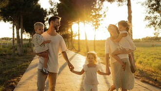 Bathed in the warm glow of sunset, a family enjoys a leisurely walk together, celebrating connection and togetherness