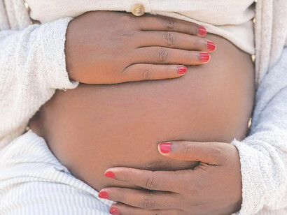 Mulher grávida acaricia a barriga