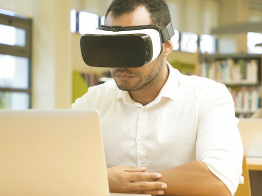 Focused on his VR study session, the student contemplates the unique role of human needs in shaping neural networks, a process artificial intelligence cannot replicate due to its lack of physiological balance