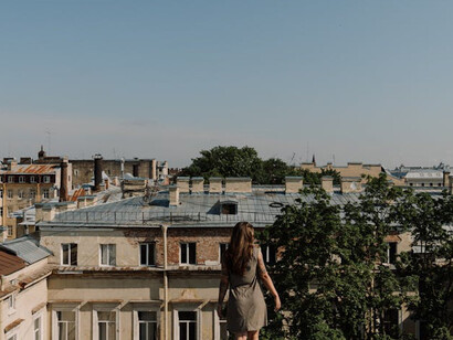 From rooftop heights, the city stretches out under a serene blue canvas, a stark contrast to the turmoil of sleepless nights and unanswered questions