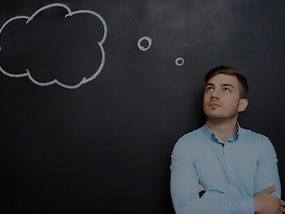 Confused bearded man standing in front of black board