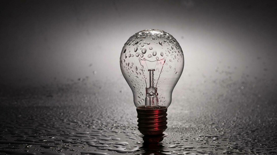 A lightbulb drizzled in water and raising the awareness to the question of whether or not water can store energy