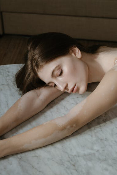 Calm woman laying with her head on a table, relaxed and at peace with herself