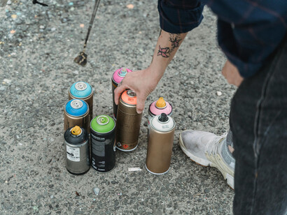 Artista agita lata de spray para aquecer a tinta acrílica