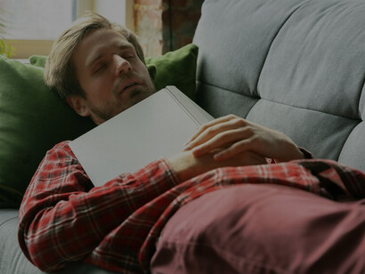 A young man reclining on the sofa at home highlights the laziness promoted by convenience culture