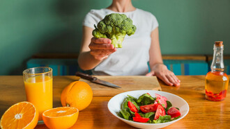 A women showcasing a variety of rich nutrient vegetables and fruits providing a more successful cleanse