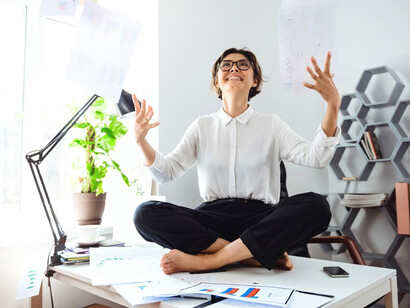 Businesswoman utilizing stress relief techniques at her workplace desk, showcasing practical approaches to handling work-related stress and enhancing overall wellness