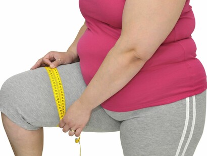 Mujer obesa tomando medidas de su cuerpo