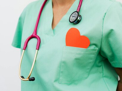A red heart peeps from a medical professional's breast pocket