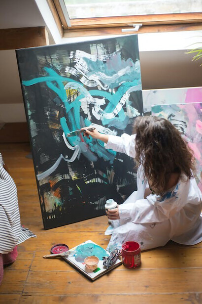 A woman passionately painting on a canvas
