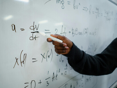 Pizarrón de una clase, donde un profesor señala algo