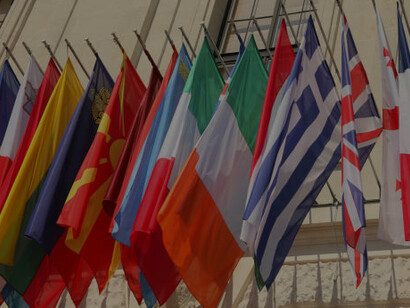 A row of European country flags displayed on a building, symbolizing the Erasmus program, European identity, and EU unity