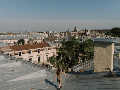 Walking the rooftops, gazing at the city's skyline, she finds solace under a bright, clear sky, contrasting the turbulent emotions within
