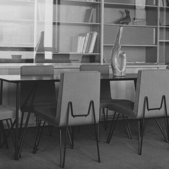 Das Büro des Geschäftsführers mit einem wandmontierten Bücherregal und einem Konferenztisch
sowie den Stühlen mit Metallgestell entworfen vom Architekturbüro Jean Tschumi