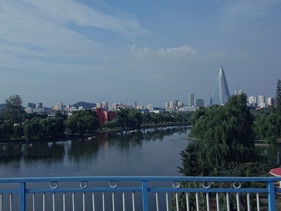 Riflessi scintillanti sul fiume Taedong che attraversa la città, offrendo una prospettiva unica dello skyline urbano, Pyongyang, Corea del Nord