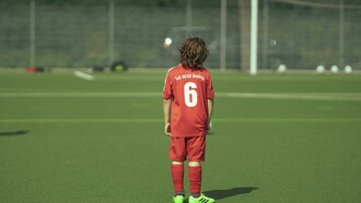 “A faceless teenage football player standing on the field