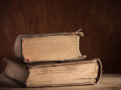 Old books on wooden table burgundy background