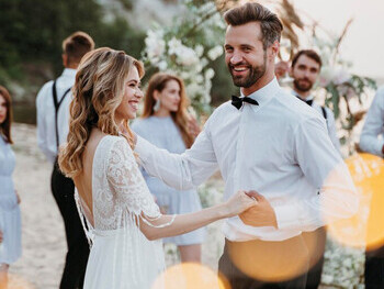 Bride and groom celebrating their beach wedding with guests, having a memorable and fun-filled day by the shore