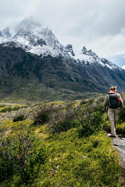 Woman hikes up a mountain trail