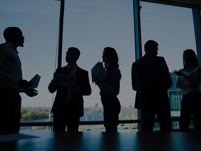 Silhouettes of business people engaged in discussions, representing diplomatic negotiations and fostering international cooperation