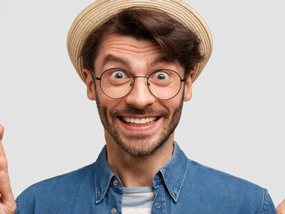 The poignant portrayal of a brunet man in a denim shirt and hat, symbolically crossing his fingers as he gracefully lets go of expectations, inviting viewers to embrace the beauty of surrender captured in this evocative image