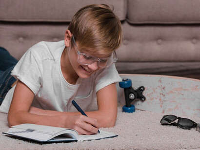 A boy is engaged in critical thinking as he writes in his agenda, showcasing the importance of creative problem-solving among young learners