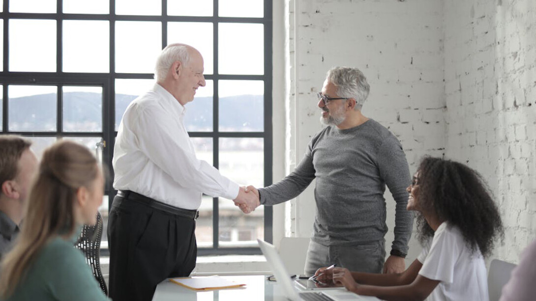 In a powerful moment of transition, the seasoned leader passes the baton to the next generation, embodying the grace and responsibility of effective leadership succession