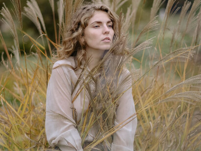 Una ragazza seduta in un campo di grano osserva l'orizzonte