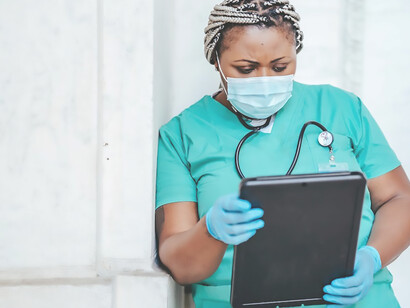 A successful doctor wearing a mask is reading the chart in her hand