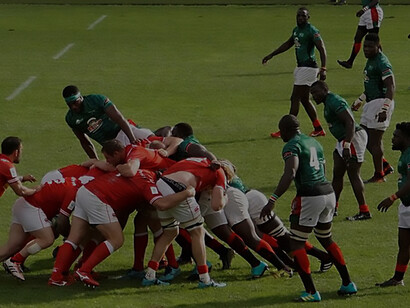 Canada's forwards apply pressure on Kenya in a maul during an intense rugby match, demonstrating the physicality and strategic gameplay of the sport