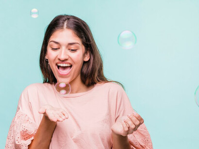 A joyful girl delights in playing with shimmering soap bubbles, her laughter and positivity illuminating the moment