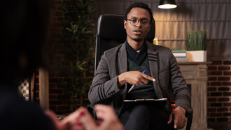 A male psychotherapist conducting a psychoanalysis session with a couple in his office, offering relationship guidance