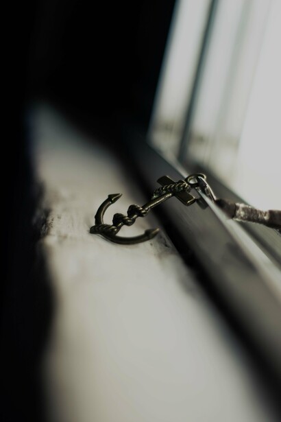 Anchor styled keychain abandoned on shabby windowsill
