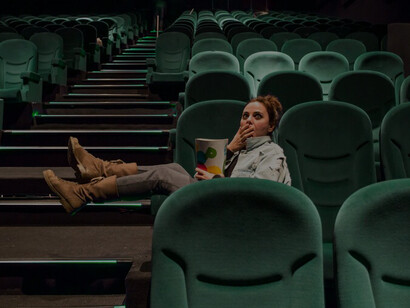 Movie theater ambiance with a girl enjoying popcorn, capturing the essence of cinematic delight