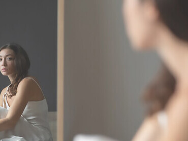 Embark on a visual journey as a woman contemplates her reflection in the mirror, symbolizing self-understanding and the transformative aspects of personal growth