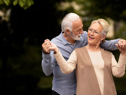 An elderly couple dancing happily in the park is a perfect example of physical health, positive lifestyle, and healthy living