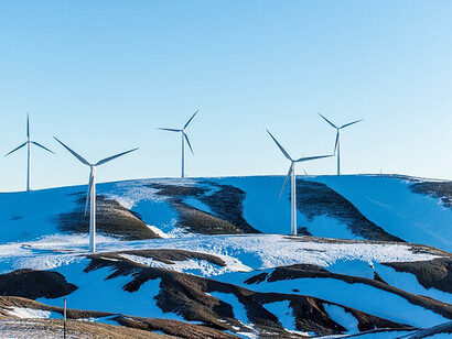Windmills surrounded by snow-covered field during daytime
