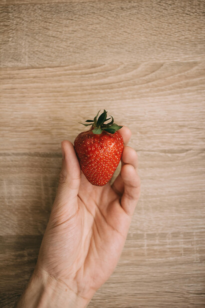 Mano con fragola succulenta