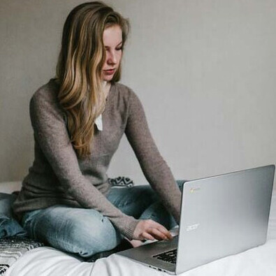 A woman working on her laptop at night; using laptops and phones at night can trigger adverse physical and psychological responses