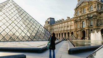 A woman photographs a building in Paris, Île-de-France, France
