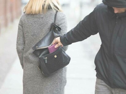 Pickpocketer in mid-action on the streets of Paris, France