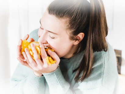 A woman shoveling chips into her mouth, a common unhealthy snack food