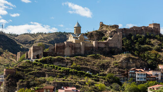 Castelo medieval de Narikala em Tbilisi, capital da Geórgia. O país está localizado no continente europeu, e também, asiático, prometendo o dobro de cultura! Suas terras abrigam algumas das cidades mais antigas do mundo, além da rica história representada pelos belos castelos medievais e antigas construções espalhadas. É claro, não pode se descartar a culinária característica e tão elogiada pelos turistas