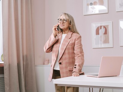A senior citizen conducting business on the phone as she contributes to the silver economy