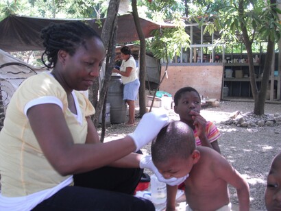 Tita Waldo Quinto curando a un niño haitiano