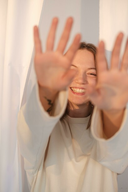 A young woman smiling and cheering up for herself and life, with positive vibes and attitude