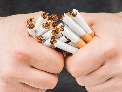Hands breaking bundle of cigarettes